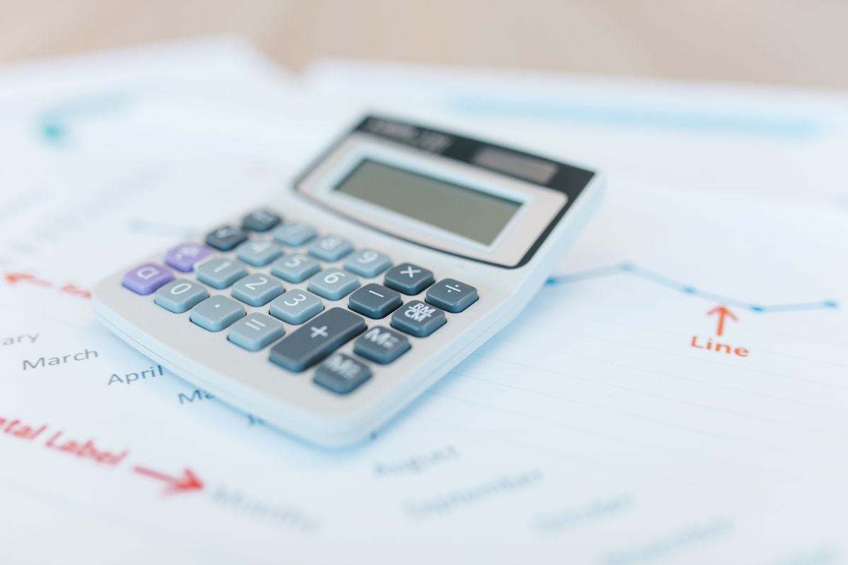 آلة حاسبة على مستندات مالية ورسوم بيانية