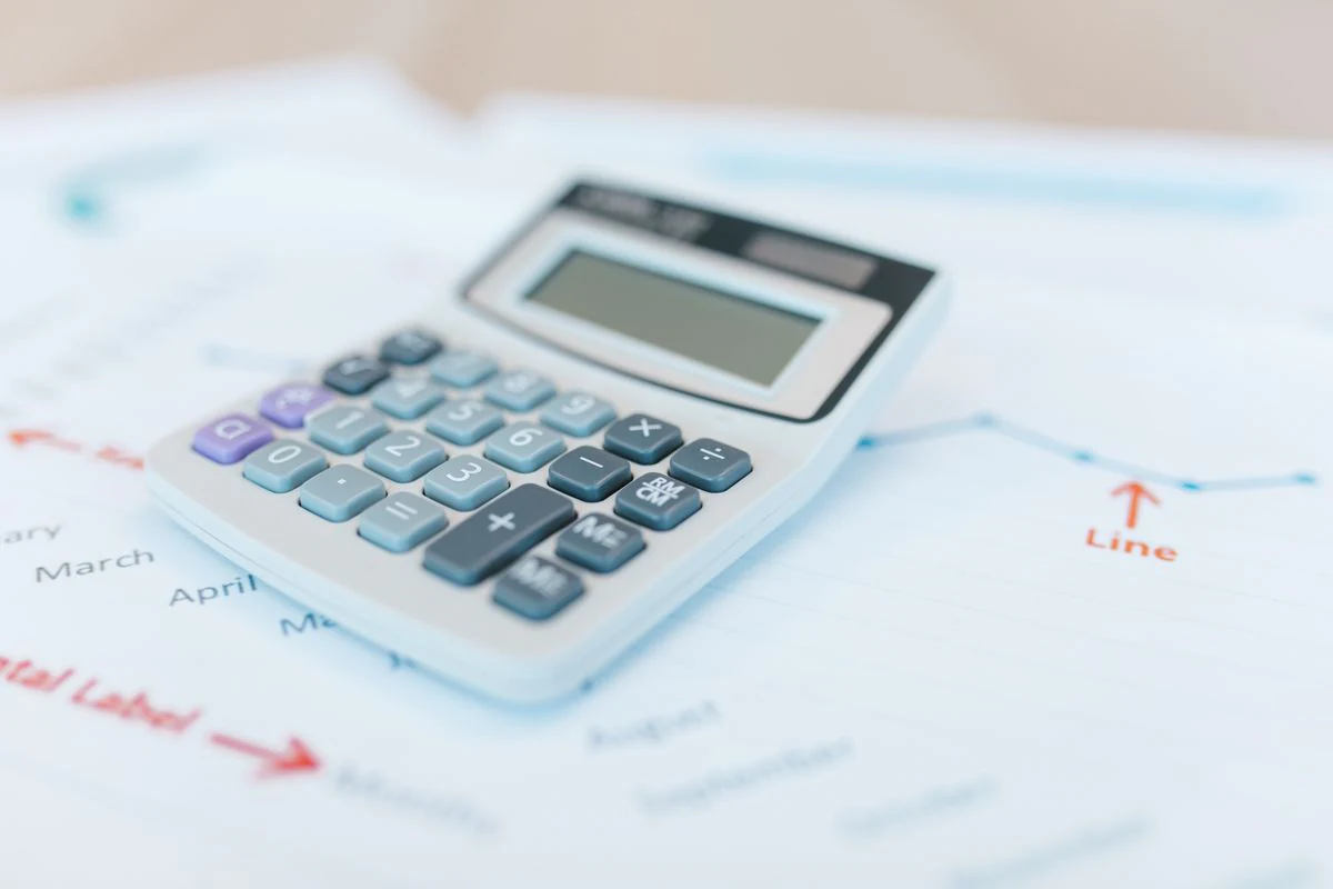 آلة حاسبة على مستندات مالية ورسوم بيانية