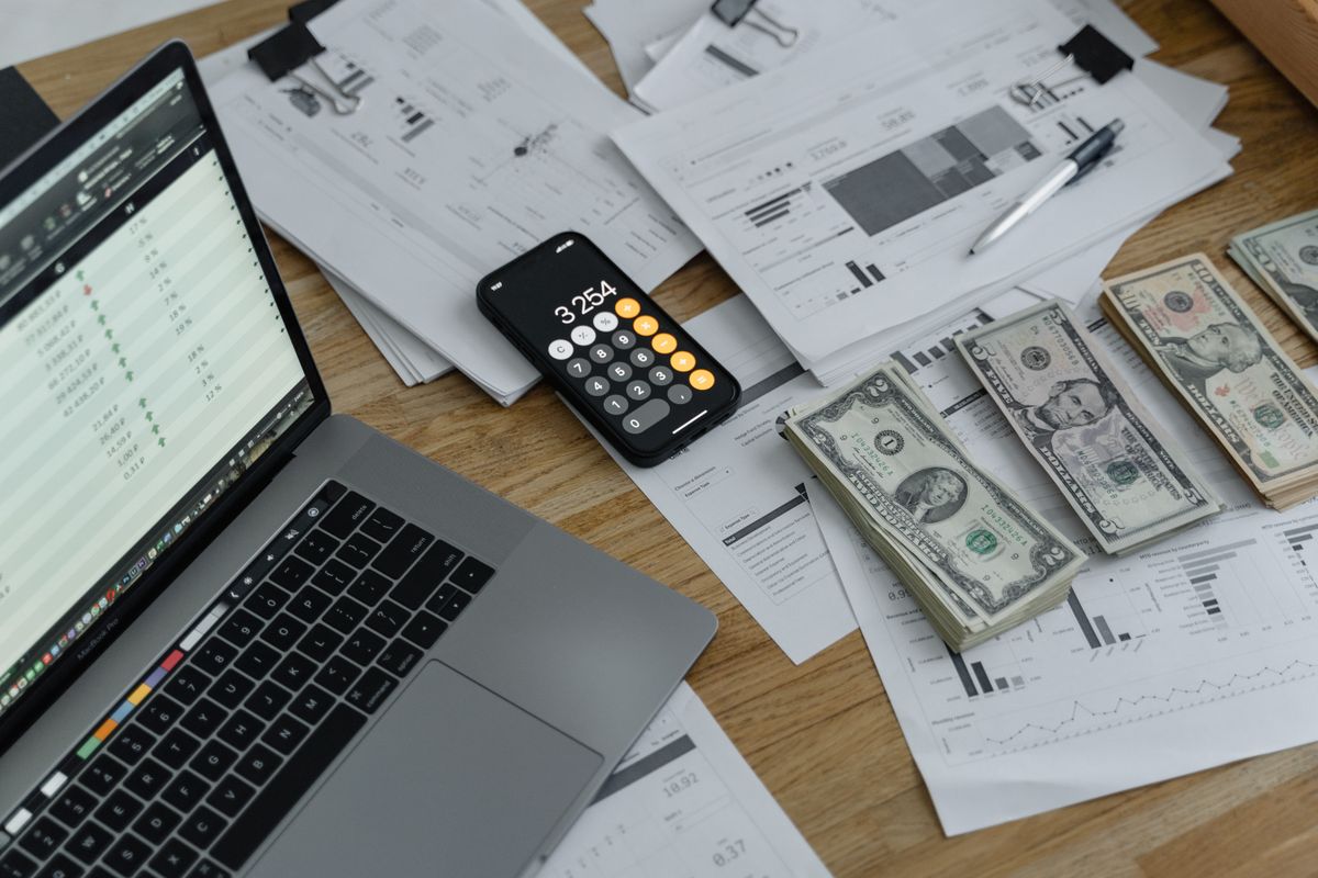 أوراق نقدية وآلة حاسبة على طاولة